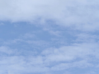 Clear blue sky with scattered light clouds creating peaceful and calm atmosphere, perfect for outdoor activities or relaxing moments. sky appears bright and serene, evoking sense of tranquility