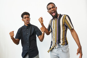 Excited black men expressing joy, celebrating triumph with fists raised, showcasing camaraderie and...