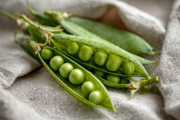 Close-up of fresh green peas in pod on textile background