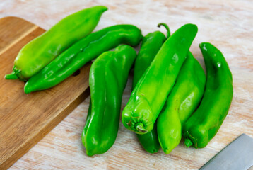 Whole organic green peppers on wooden table, vegetable ingredients for cooking