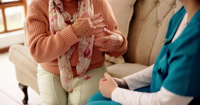 Hands, nurse and old woman on sofa, consultation and explain with wellness, talking and cardiology. Service, home and caregiver with pensioner, senior person and heart condition with healthcare