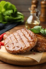 Delicious hamburger patties and spices on wooden table, closeup