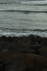 View of beautiful wavy sea and many stones, closeup