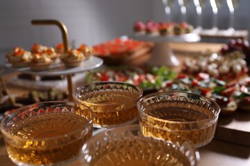 Buffet menu. Glasses of sparkling wine and tasty appetizers on table, closeup