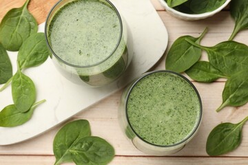 Tasty smoothie and spinach leaves on white wooden, flat lay