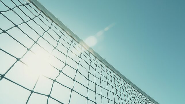 A volleyball net is set against a clear blue sky on a sunny day