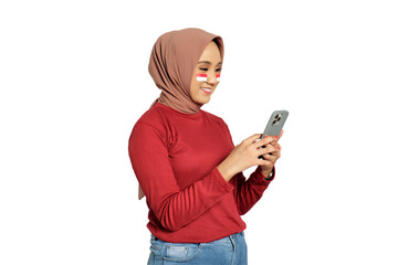 Happy young Asian women celebrate Indonesian independence day on 17 August while holding mobile phone isolated on transparent background