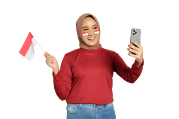 Excited young Asian women celebrate Indonesian independence day on 17 August by holding the Indonesian flag and mobile phone isolated on transparent background