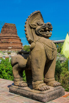Qilin statue with intricate details standing in a temple courtyard, representing mythical creature in Chinese culture, traditional Asian art, symbolism, and cultural heritage under natural daylight