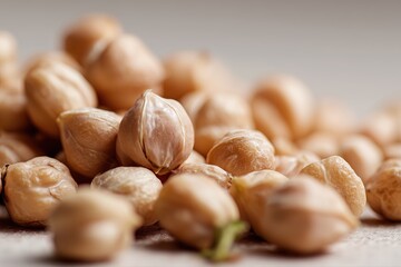 A close-up shot of chickpeas, showcasing their small size and texture. The background is neutral to highlight the chickpeas