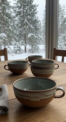 Rustic Ceramic Bowls on Wooden Table with Snowy Winter Forest View