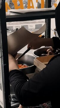 an Indonesian traditional food seller serving gudeg to customer. an Indonesian seller serving customer order