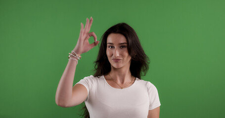 Happy young woman gesturing ok sign with hand on chroma key background