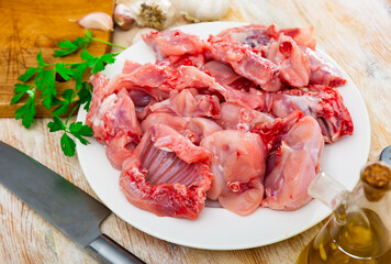 Raw sliced rabbit lying on white plate with seasonings. Dietary cooking ingredient ..