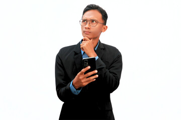 An Asian business man holding a cell phone with a thoughtful expression.