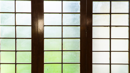 A gridded window panel showing multiple panes with blurred views of the outside