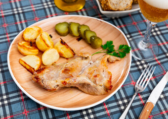 Delicious pork steak served with potatoes and pickles. Festive dinner