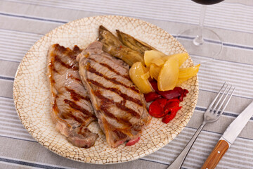 Nicely served plate of tasty beef steak with baked tomatoes calcot onion and tomatoes