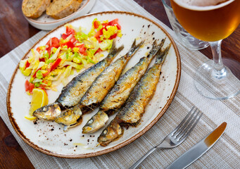 Grilled on fire sardines served with fresh greens, popular Mediterranean food