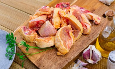 Raw poultry, fresh chopped chicken with condiments on wooden table, food preparation