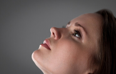 Side view portrait of a young woman looking up with hope and faith