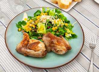 Appetizing fried quail with fresh vegetable salad served on platter