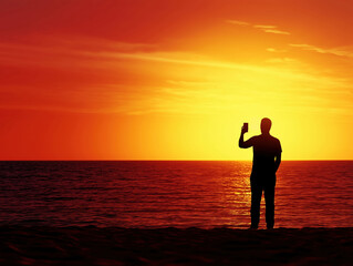 Fototapeta premium Silhouette of a person taking a selfie in front of a vibrant sunset at the beach