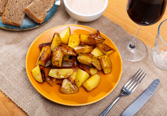Bar serves traditional Spanish beer appetizer - tapas potatoes. Slices of potatoes, toasted with...