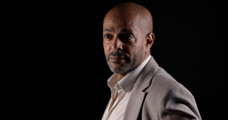 Portrait of an african american businessman wearing suit posing on a black background