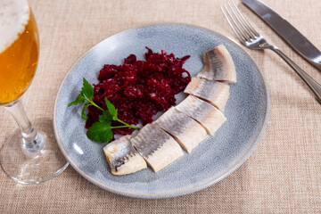 Delicious sliced lightly salted herring with beets served on platter
