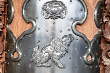 Detail of bronze decoration, lion dog image at the entrance of Hongan-Ji Temple, Kyoto, Japan. 
