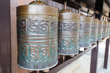 Row of bronze revolving cylidrical bells at temple in Kyoto, Japan. 
