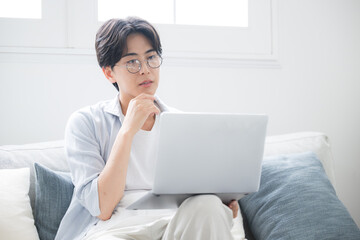  パソコンを見ながら考える男性困る悩むの表情