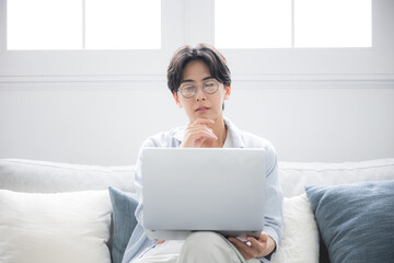  パソコンを見ながら考える男性困る悩むの表情