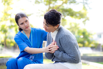 Obraz premium Caucasian woman chest pain while nurse first aid in outdoor park, emergency of patient with injury and urgency, disease of woman and aid, medical and accident, sick of patient and expression.