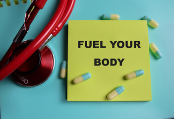 Concept of fuel your body write on sticky notes isolated on Wooden Table. healthcare and...
