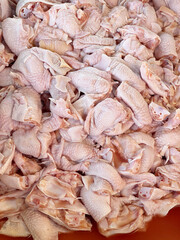 fresh raw chicken legs in a tray for sale at the market.