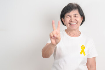 Elderly with Yellow Ribbon for concept of yellow September, Suicide prevention day, Childhood, July Sarcoma, support Our Troops and Military support. Healthcare and World Cancer day