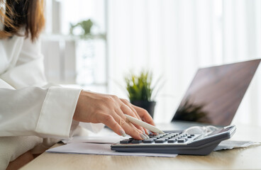 Human use calculator and calculate bills and paying bill, credit card, tax and vat, payment, concept of money management and business report with financial documents, financial accounting concept
