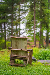Naklejka premium Wooden chair with pine trees in the background