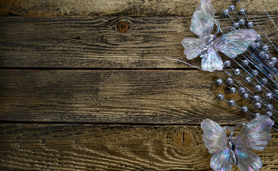 Textured wooden background with Christmas decorations, butterfly, snowflake, silver glitter flowers . Merry Christmas and Happy New Year . Copy space . Greeting card