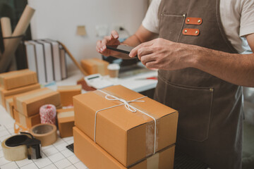 he is checking the boxes in the packing room, a small business owner is preparing boxes to ship to...