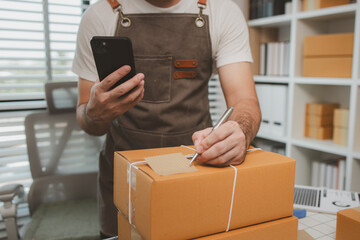 he is checking the boxes in the packing room, a small business owner is preparing boxes to ship to...