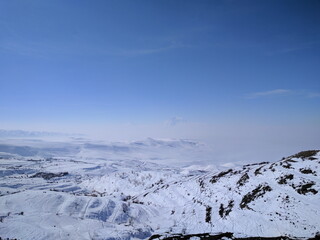Vast snowy mountain landscape under a clear blue sky. Panoramic winter wonderland scenery in a...