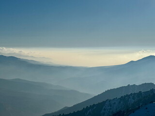 Hazy blue mountain range layers with atmospheric perspective. Serene and vast mountain landscape...