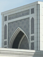 Arabic calligraphy inscription above an ornate archway. Detail of modern Islamic architecture with...