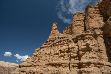 A wall of a wind blown and carved rock formation canyon. Sunny day, blue sky in the background....
