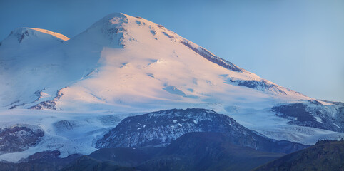 Morning light on the peaks of Mount Elbrus, sunrise in the Caucasus mountains, travel and climbing