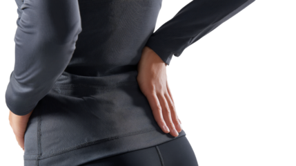 Person wearing black long sleeved athletic shirt places hand on lower back.
