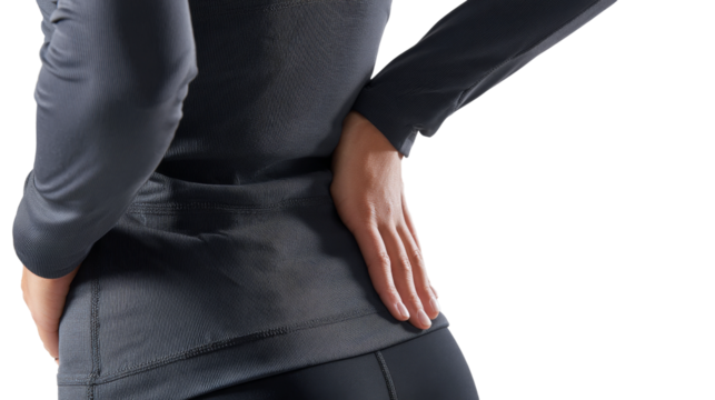 Person wearing black long sleeved athletic shirt places hand on lower back.
